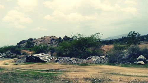 Built structure on landscape against cloudy sky