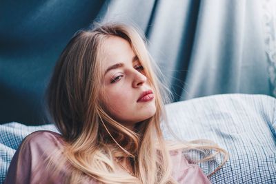 Beautiful young woman looking away on bed