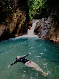 Full length of young woman swimming in river