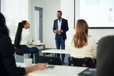 Businessman presenting before colleagues during meeting