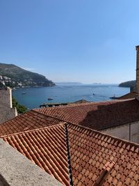 Scenic view of sea by building against clear blue sky