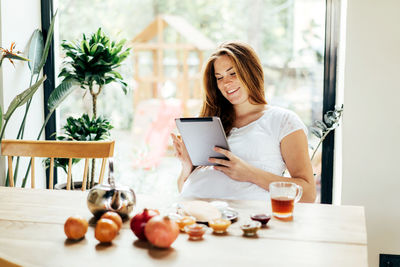 Pregnant freckled redhead woman surfing computer gadget tablet 