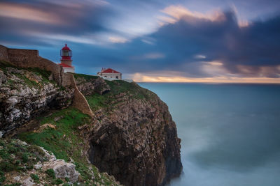 Lighthouse by sea against sky