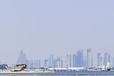 Doha, qatar, november 2, 2023. traditional wooden arab dhow in front of skyscrapers