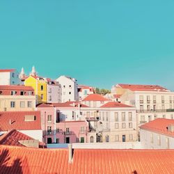 Buildings in city against clear blue sky