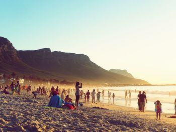 People on beach against clear sky