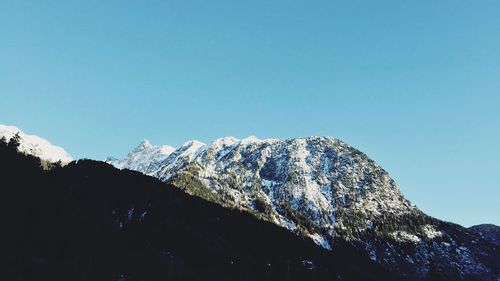 Scenic view of snowcapped mountains against blue sky