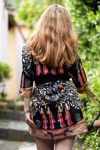 Rear view of woman standing by plants