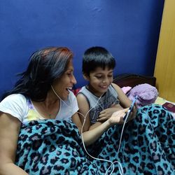 Rear view of mother and daughter using phone