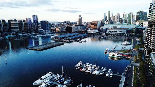 High angle view of buildings by harbor against sky