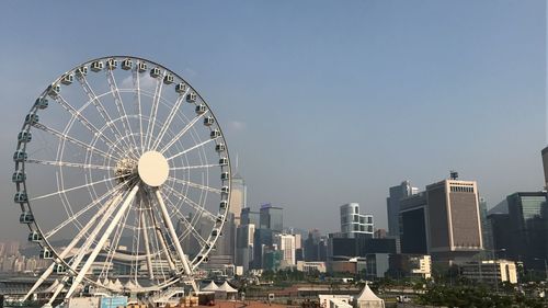 Ferris wheel in city against clear sky