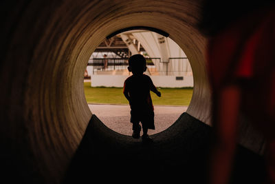 Baby boy walking in concrete tube