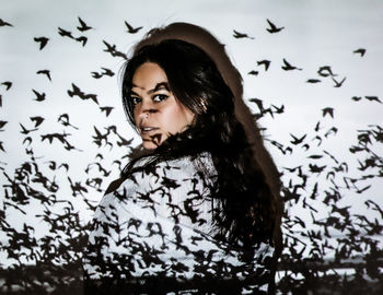 Portrait of young woman standing against wall