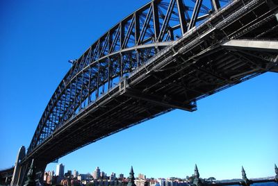 Low angle view of suspension bridge against blue sky