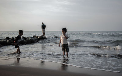 People on beach against sky