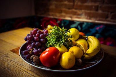 Diet fresh tasty mix fruit salad on a plate on wooden table, healthy breakfast, weight loss concept