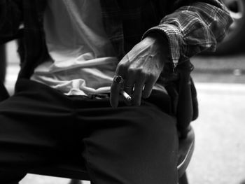 Midsection of man holding cigarette outdoor