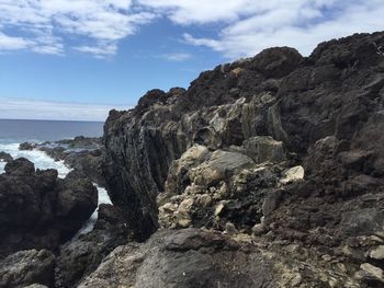 Rock formations by sea against sky