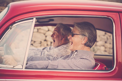 Cheerful senior couple traveling in car