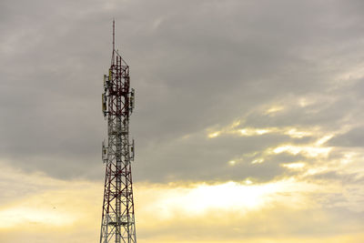 Low angle view of electricity pylon against sky during sunset