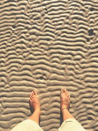 Low section of woman standing at beach