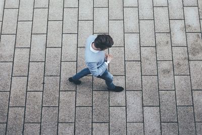 High angle view of man walking on footpath