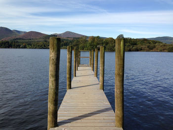 Wooden pier on lake against sky