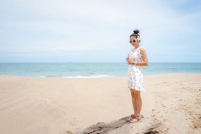 Portrait of beautiful woman standing at beach