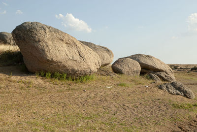 Rock formation on field against sky