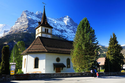 Trees in front of church against sky