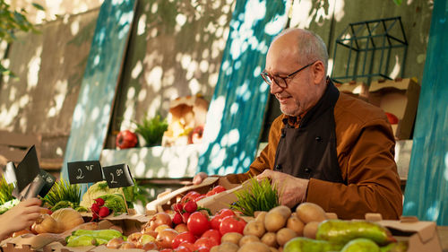 Portrait of senior man with vegetables at market