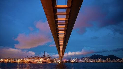 Low angle view of illuminated bridge over sea against sky