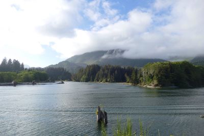 Scenic view of sea and mountains against cloudy sky