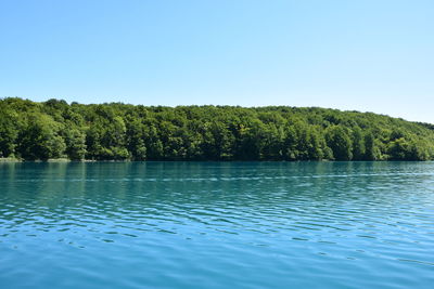 Scenic view of lake against clear blue sky