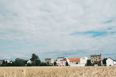 Rural landscape against cloudy sky