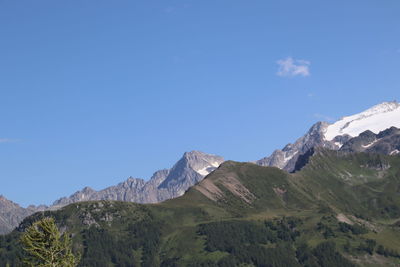 Scenic view of mountains against blue sky