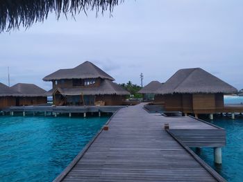 Houses by swimming pool by sea against sky