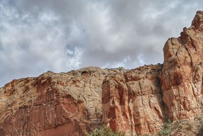 Rock formations on mountain against cloudy sky