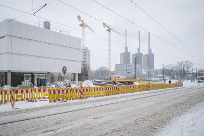 Vehicles on road against sky in winter