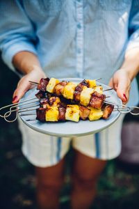 Midsection of man preparing food on barbecue grill