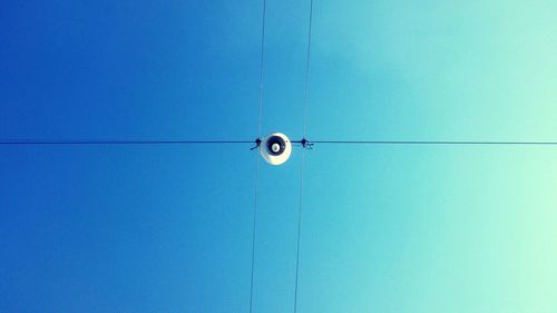 Low angle view of electricity pole against blue sky