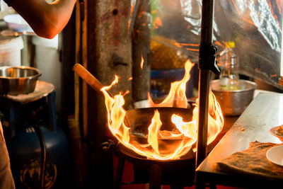 Midsection of chef preparing food in commercial kitchen