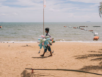 Full length of boy on beach against sky