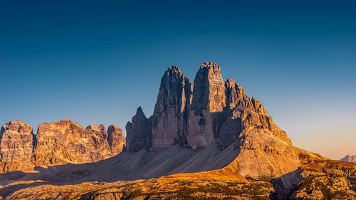 Rock formations on mountain against blue sky