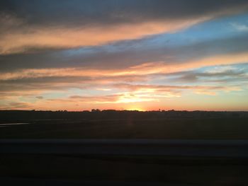 Scenic view of silhouette landscape against dramatic sky during sunset