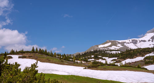 Scenic view of snowcapped mountains against blue sky