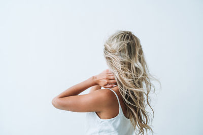 Rear view of woman standing against white background