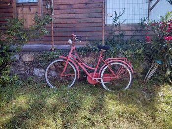 Bicycle parked on field by abandoned building