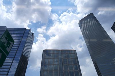 Low angle view of modern building against cloudy sky