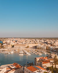 Cityscape and lake against clear sky
